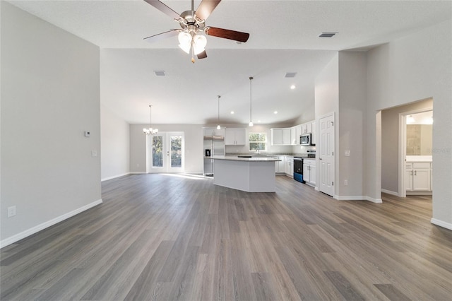 unfurnished living room featuring baseboards, visible vents, and wood finished floors