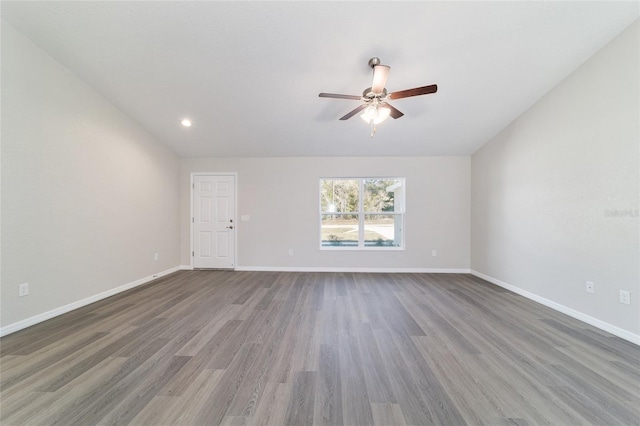 unfurnished room with ceiling fan, wood finished floors, and baseboards