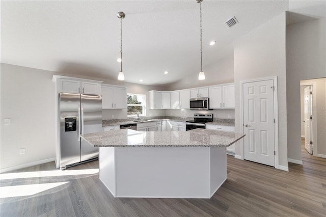 kitchen featuring appliances with stainless steel finishes, a kitchen island, decorative light fixtures, and white cabinets