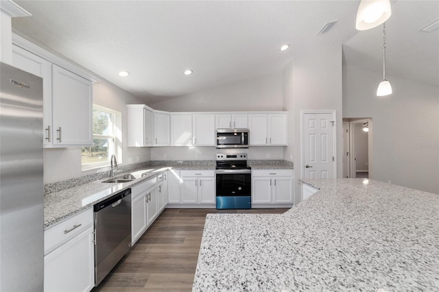 kitchen with white cabinets, light stone countertops, stainless steel appliances, pendant lighting, and a sink