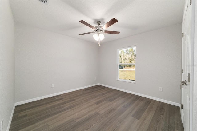 unfurnished room with a ceiling fan, baseboards, and dark wood-style flooring