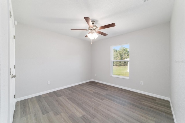 spare room with a ceiling fan, baseboards, and wood finished floors