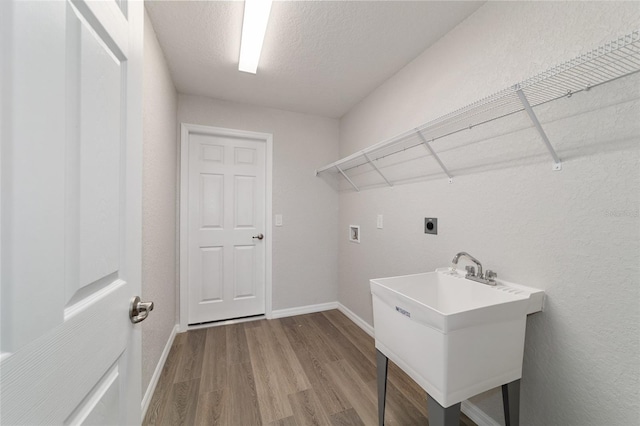 laundry area featuring hookup for a washing machine, a sink, electric dryer hookup, wood finished floors, and laundry area