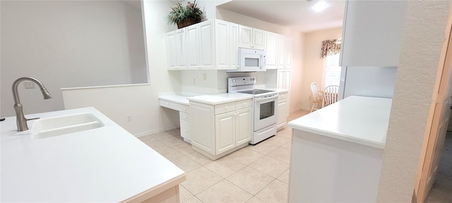 kitchen with white appliances, light countertops, white cabinetry, a sink, and light tile patterned flooring