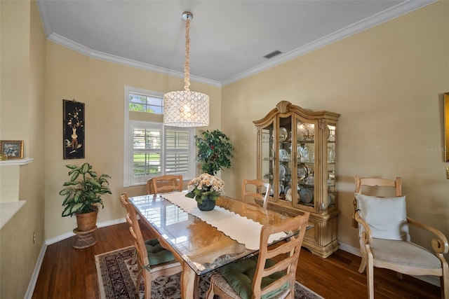 dining space with dark wood-style flooring, crown molding, and baseboards