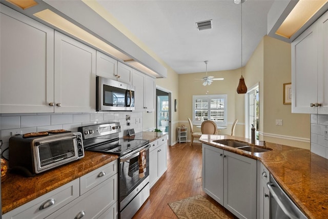 kitchen with pendant lighting, a toaster, visible vents, appliances with stainless steel finishes, and white cabinetry