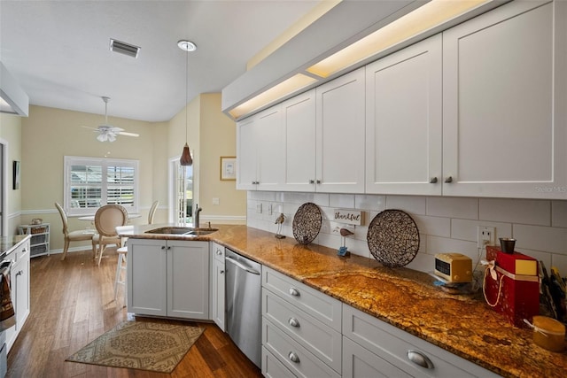 kitchen with dark wood-type flooring, a sink, visible vents, white cabinetry, and stainless steel dishwasher