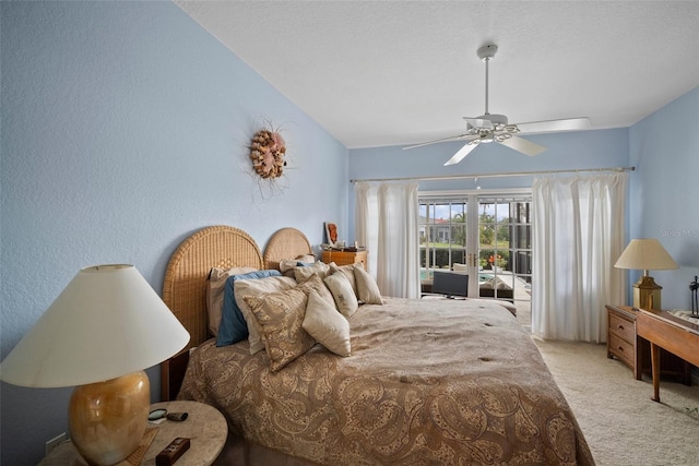 bedroom with a textured wall, a ceiling fan, light carpet, vaulted ceiling, and a textured ceiling