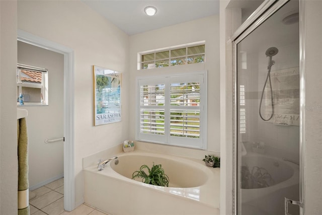 bathroom with a shower stall, a bath, and tile patterned floors