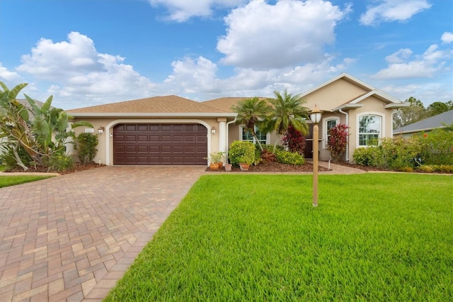 single story home with an attached garage, decorative driveway, a front yard, and stucco siding