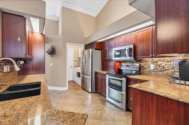 kitchen with tasteful backsplash, appliances with stainless steel finishes, ornamental molding, a sink, and light stone countertops