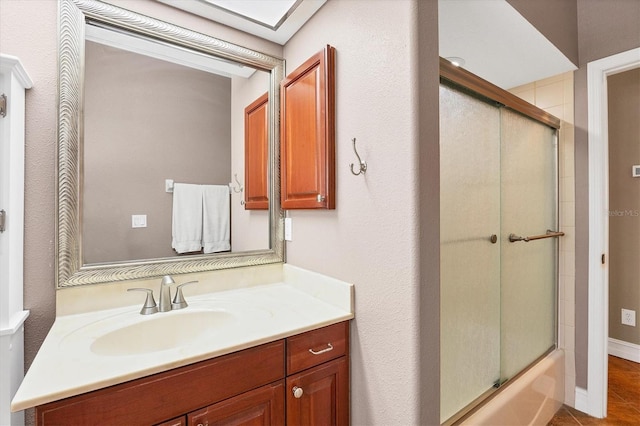 bathroom featuring enclosed tub / shower combo, tile patterned flooring, and vanity