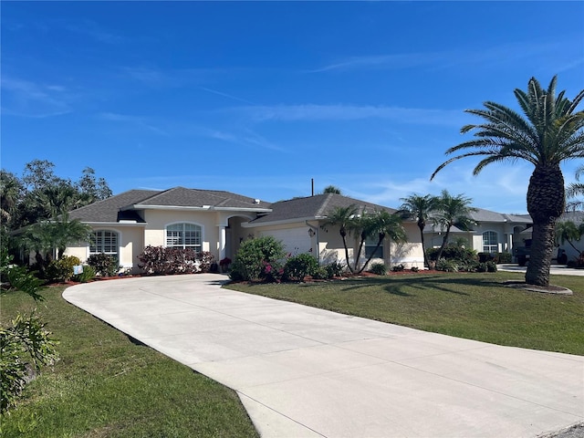 view of front of house with a garage, a front lawn, concrete driveway, and stucco siding