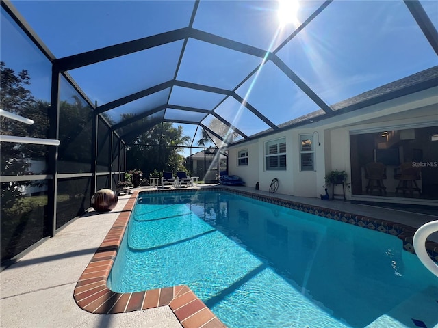 pool with glass enclosure and a patio