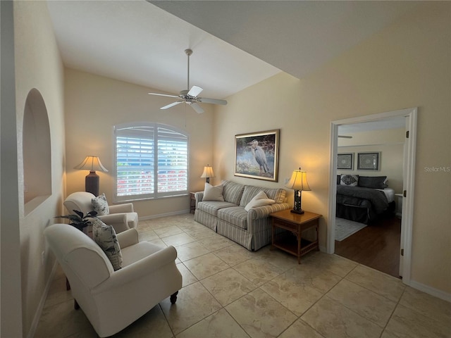 living area featuring light tile patterned floors, ceiling fan, and baseboards