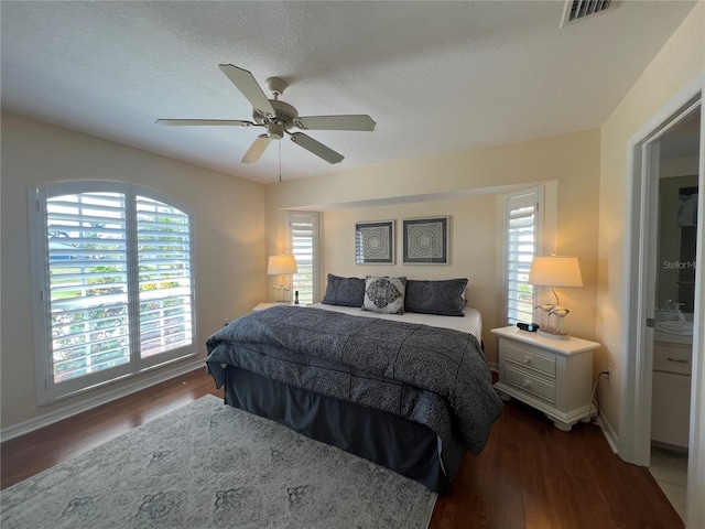 bedroom featuring baseboards, visible vents, ceiling fan, wood finished floors, and a textured ceiling