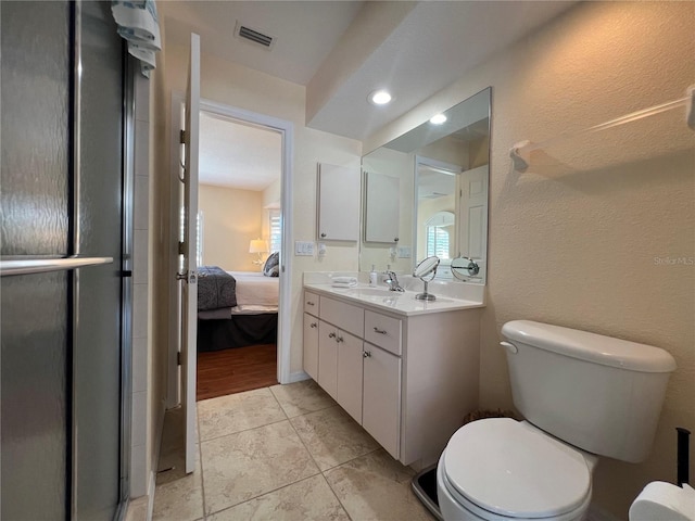 ensuite bathroom featuring visible vents, a textured wall, toilet, vanity, and ensuite bath