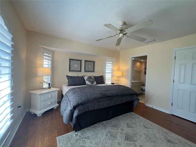 bedroom with dark wood-style flooring, visible vents, a ceiling fan, connected bathroom, and baseboards