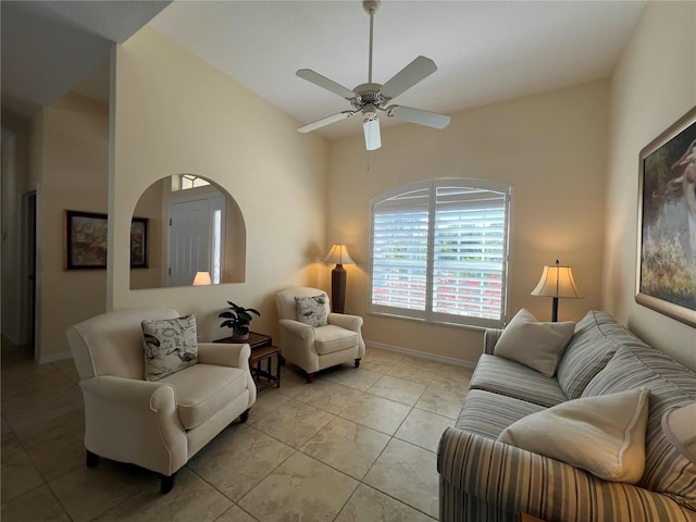 living area with ceiling fan, light tile patterned flooring, and baseboards