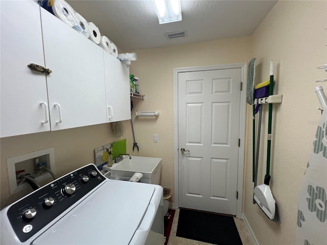 washroom with visible vents, cabinet space, a sink, and washer / dryer