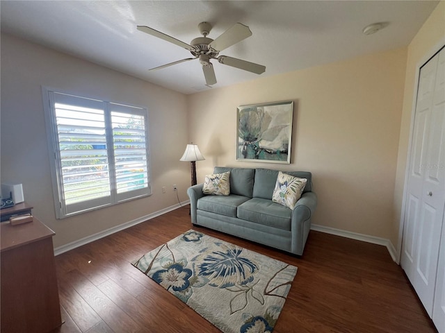 living area with wood finished floors, a ceiling fan, and baseboards