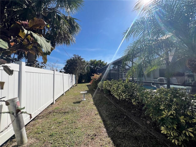 view of yard featuring a lanai and fence