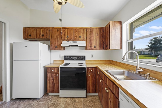 kitchen featuring light countertops, vaulted ceiling, a sink, white appliances, and under cabinet range hood