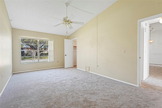 carpeted empty room featuring a ceiling fan, lofted ceiling, a textured ceiling, and baseboards