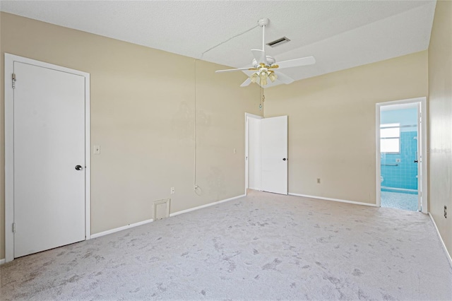 unfurnished bedroom featuring carpet floors, visible vents, baseboards, and ensuite bathroom