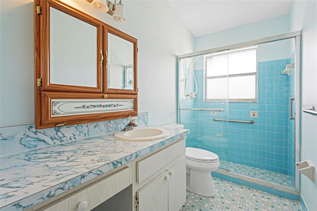 full bathroom featuring toilet, a shower stall, tile patterned flooring, and vanity