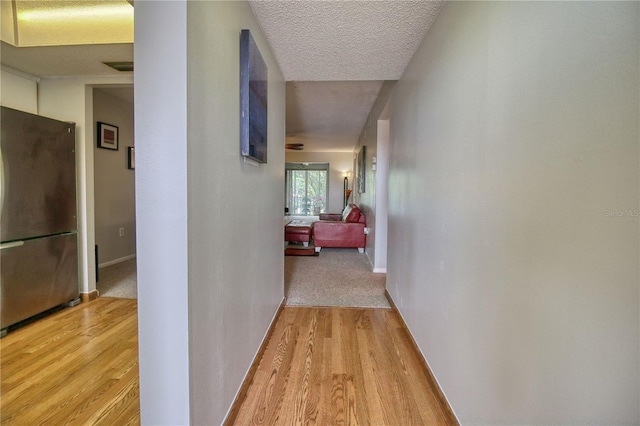 3658 Lake Bayshore Dr Unit 320, Bradenton, FL 34205 - corridor with light wood-style floors, a textured ceiling, and baseboards