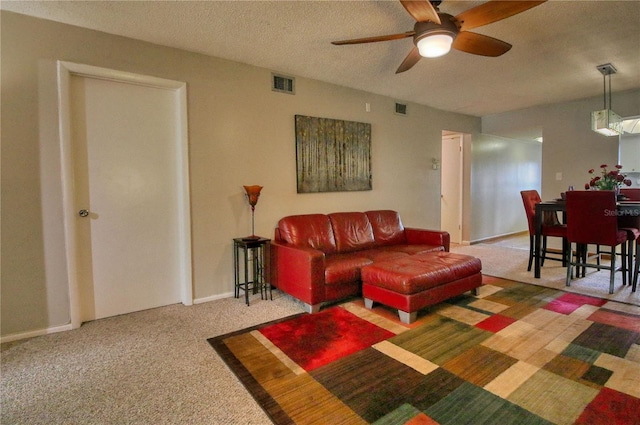 3658 Lake Bayshore Dr Unit 320, Bradenton, FL 34205 - carpeted living room featuring a textured ceiling, baseboards, visible vents, and a ceiling fan