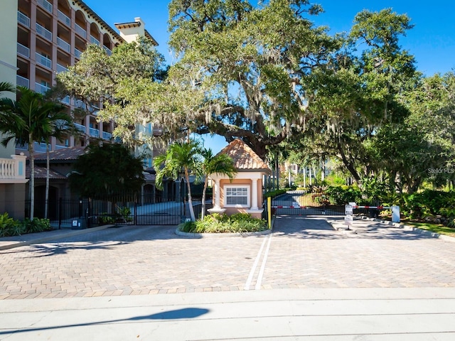 exterior space with curbs, a gated entry, and a gate