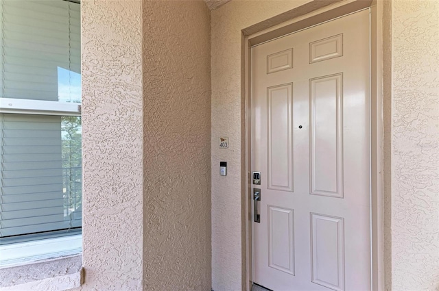 entrance to property with stucco siding