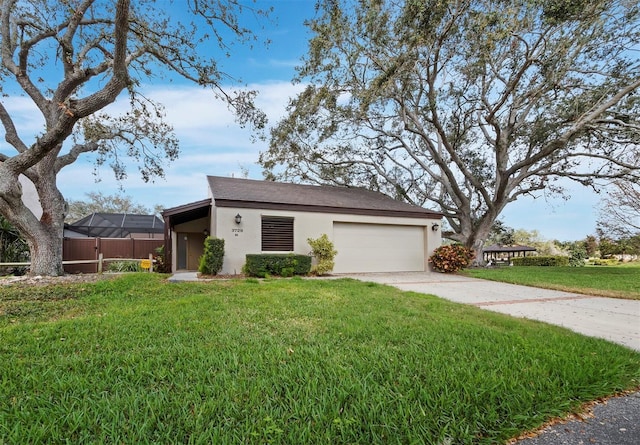 view of front of property with an attached garage, fence, concrete driveway, stucco siding, and a front lawn