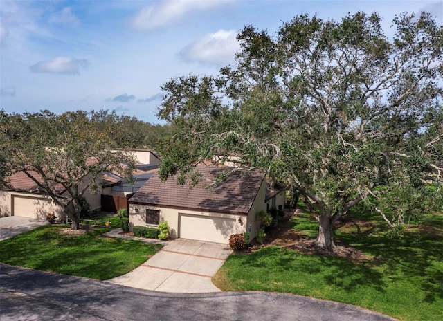 view of front of house featuring a garage, a front lawn, and concrete driveway