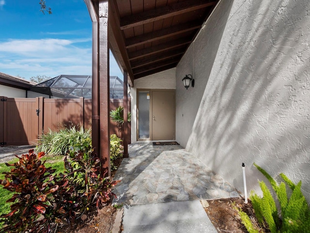 doorway to property with fence, a gate, and stucco siding