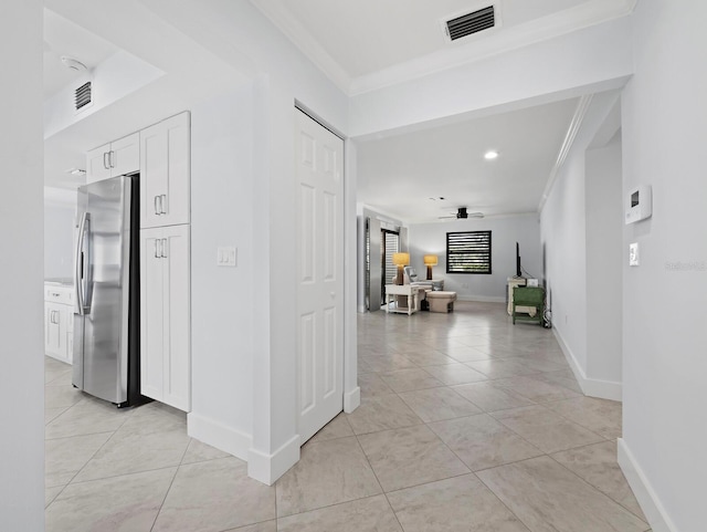 corridor with ornamental molding, visible vents, and light tile patterned floors