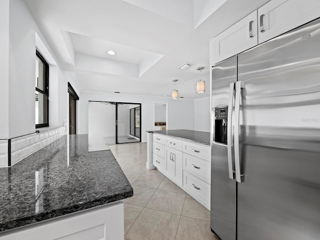 kitchen featuring a peninsula, a tray ceiling, stainless steel refrigerator with ice dispenser, and white cabinetry