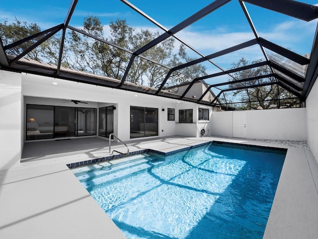 outdoor pool with glass enclosure and a patio