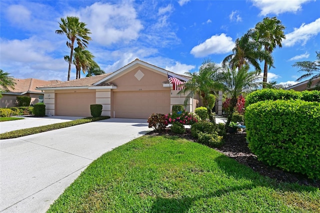 view of front facade featuring stucco siding, a garage, driveway, a tiled roof, and a front lawn