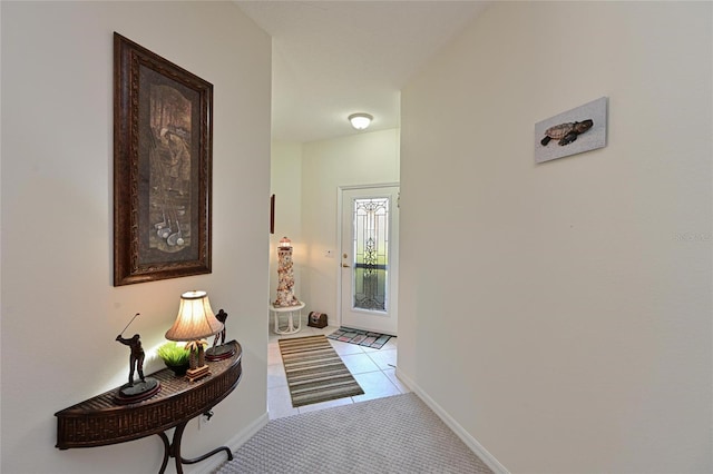 doorway featuring carpet and baseboards