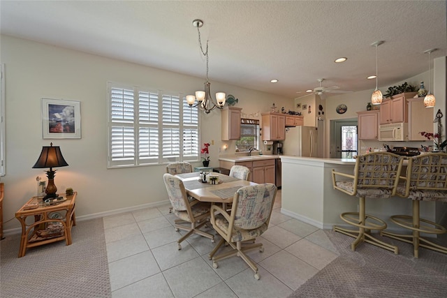 dining room featuring a textured ceiling, light tile patterned floors, recessed lighting, ceiling fan with notable chandelier, and baseboards