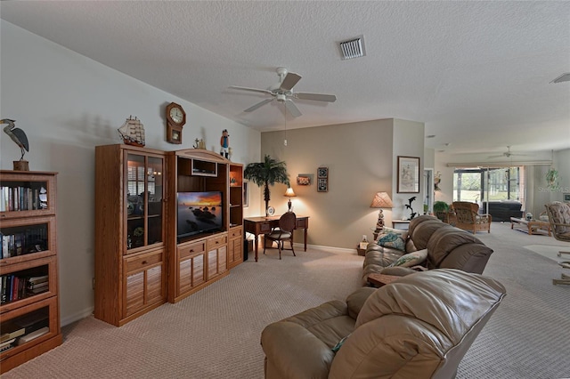 living room featuring a ceiling fan, visible vents, light carpet, and a textured ceiling