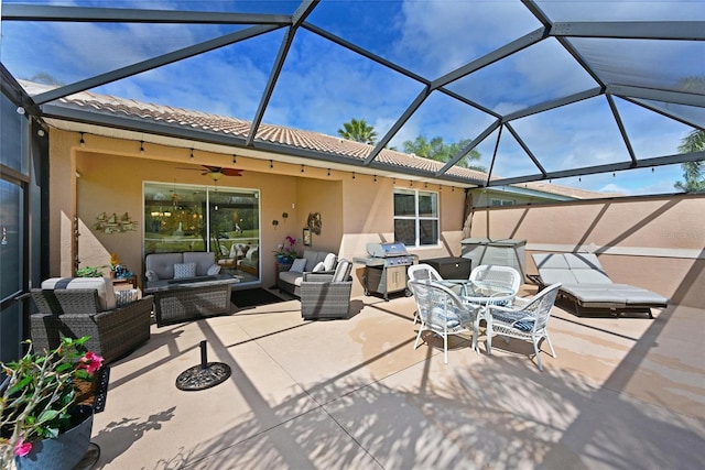 view of patio featuring a lanai, outdoor lounge area, ceiling fan, and area for grilling