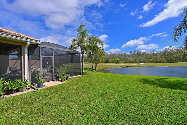 view of yard featuring glass enclosure and a water view