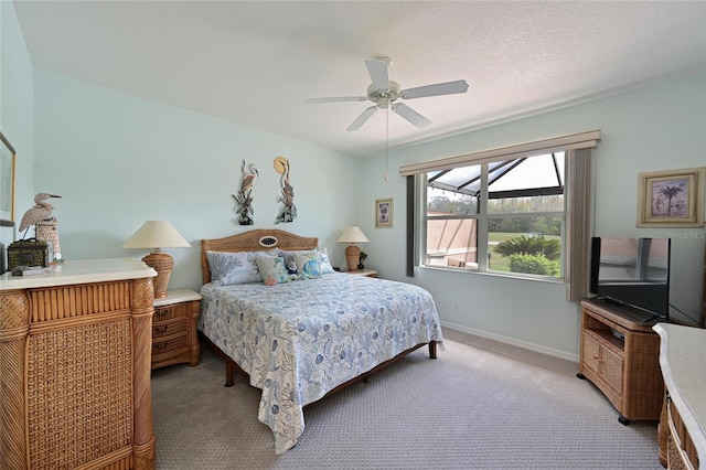 bedroom featuring a ceiling fan, light carpet, a textured ceiling, and baseboards