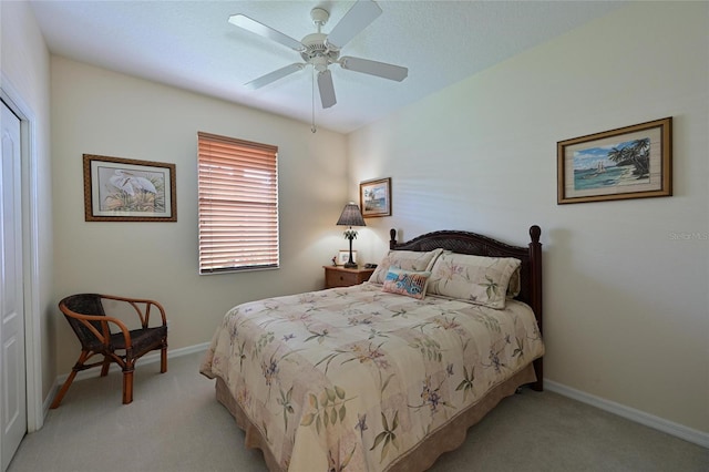 carpeted bedroom with ceiling fan and baseboards