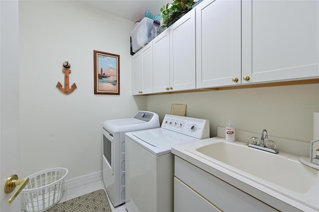 laundry area featuring cabinet space, light tile patterned floors, baseboards, independent washer and dryer, and a sink