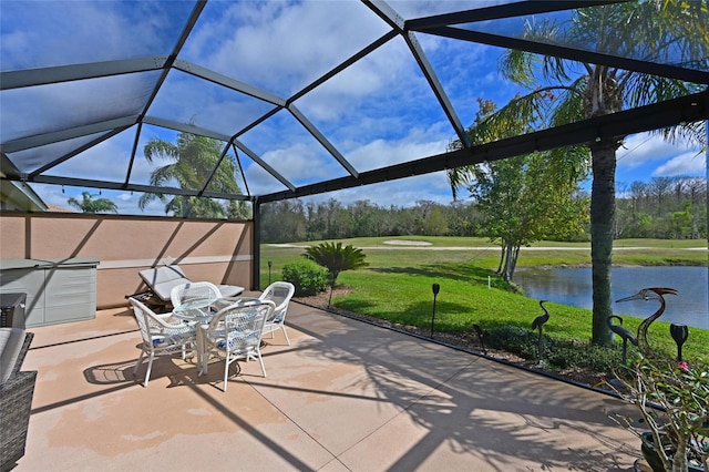 view of patio with glass enclosure and a water view